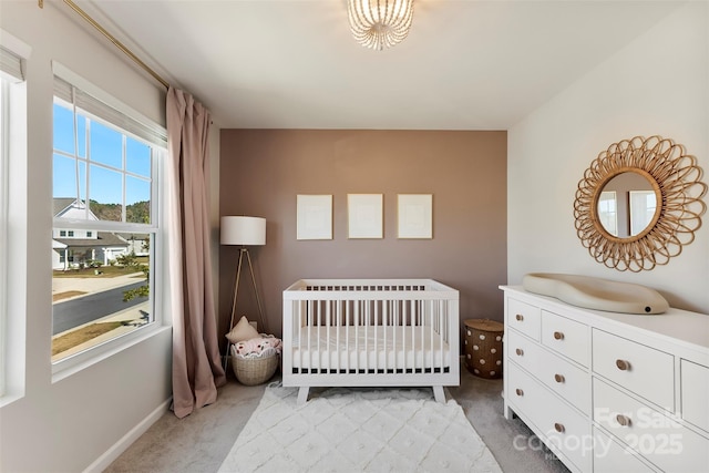 carpeted bedroom with a nursery area