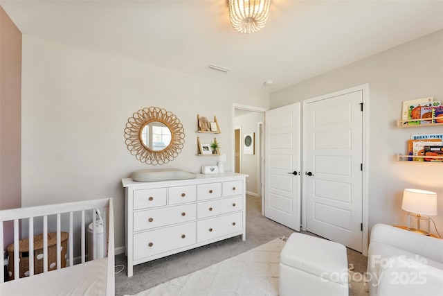 carpeted bedroom featuring a nursery area