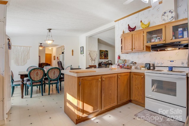 kitchen featuring lofted ceiling, decorative light fixtures, a textured ceiling, white electric range oven, and kitchen peninsula