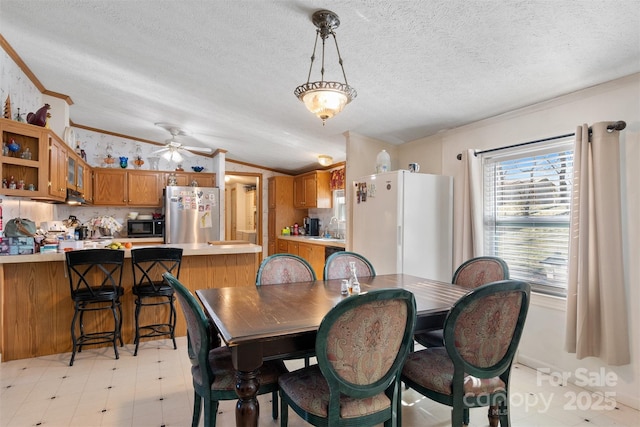 dining room with ceiling fan, crown molding, lofted ceiling, and sink