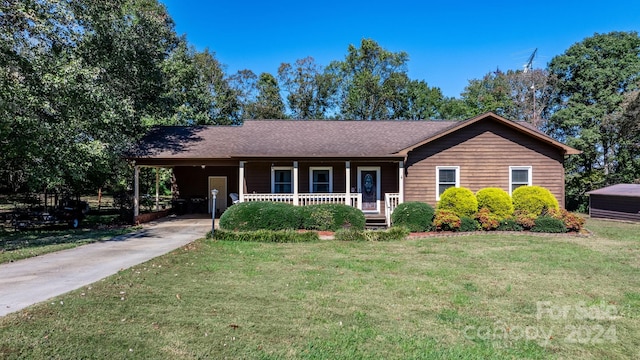 ranch-style house featuring covered porch, a front lawn, and a carport