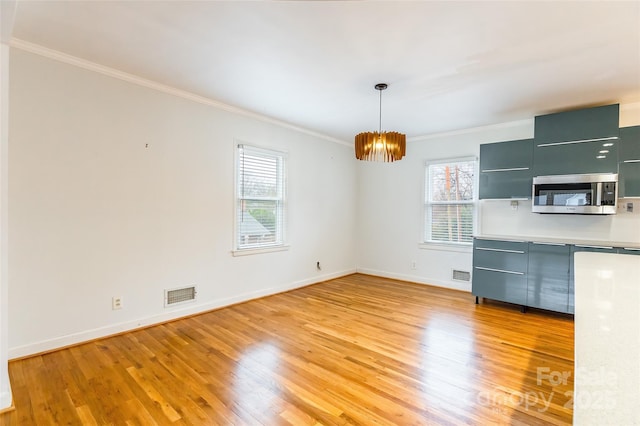 unfurnished dining area with ornamental molding, light hardwood / wood-style floors, and a chandelier