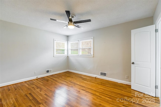 unfurnished room featuring ceiling fan, hardwood / wood-style floors, and a textured ceiling