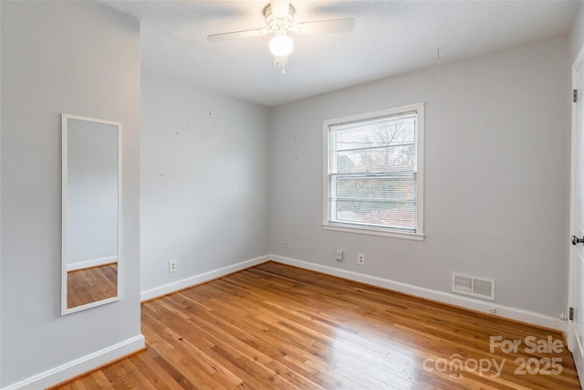 empty room with ceiling fan and light hardwood / wood-style floors