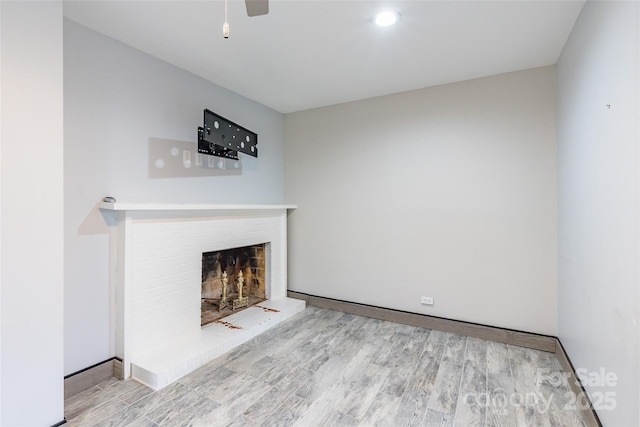 unfurnished living room with a fireplace and light wood-type flooring