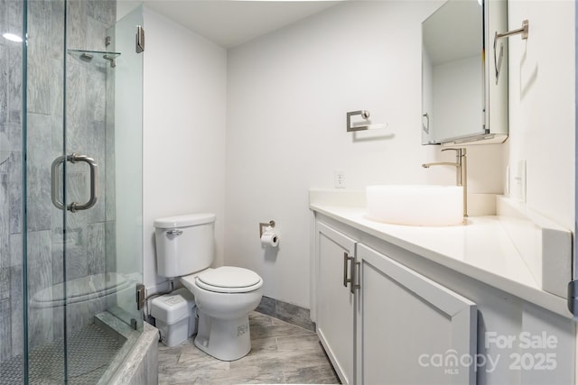 bathroom with vanity, toilet, and a shower with shower door