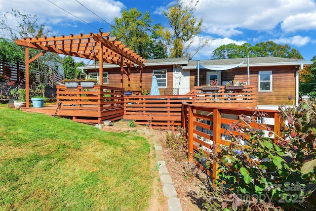 rear view of house featuring a pergola, a lawn, and a deck