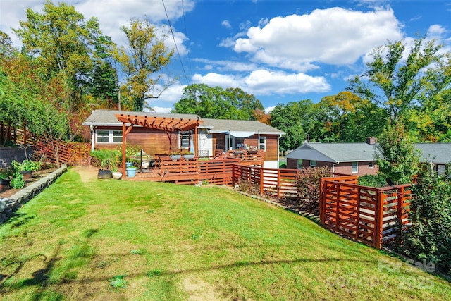 rear view of house with a pergola, a deck, and a lawn