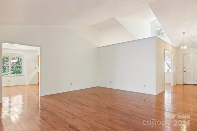 interior space featuring a notable chandelier, hardwood / wood-style flooring, and high vaulted ceiling