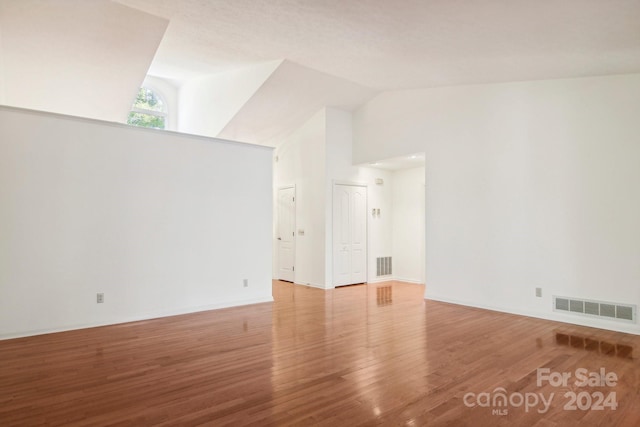 empty room featuring light hardwood / wood-style floors and high vaulted ceiling