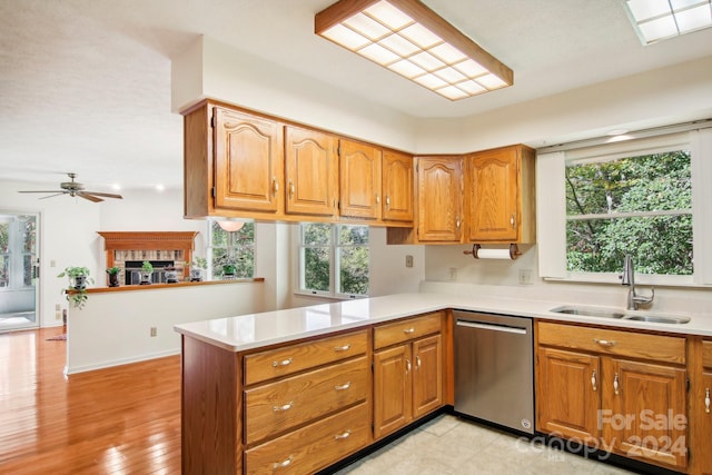 kitchen featuring kitchen peninsula, sink, light wood-type flooring, stainless steel dishwasher, and ceiling fan