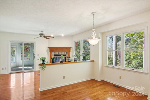 kitchen with light hardwood / wood-style flooring, hanging light fixtures, a textured ceiling, and ceiling fan