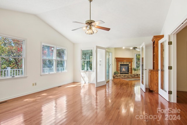 unfurnished living room with light hardwood / wood-style floors, vaulted ceiling, and a wealth of natural light