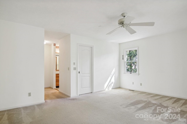 unfurnished room with light colored carpet and ceiling fan