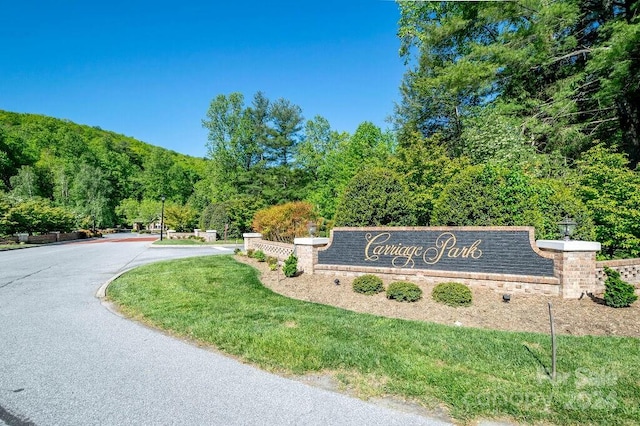 community / neighborhood sign featuring a lawn