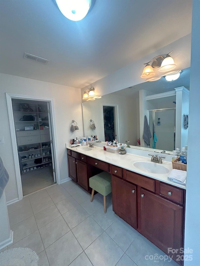 bathroom featuring tile patterned flooring, vanity, and a shower with door