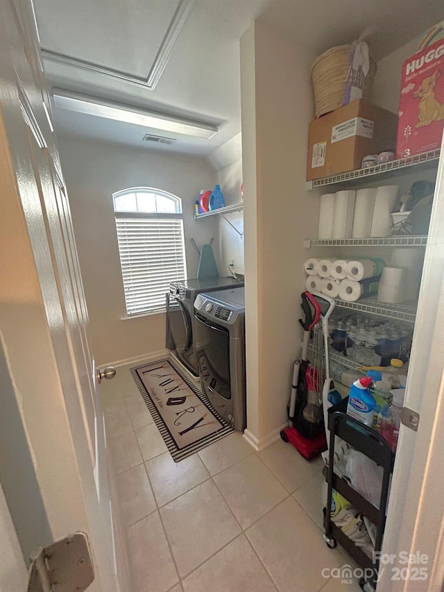 clothes washing area featuring light tile patterned flooring and independent washer and dryer