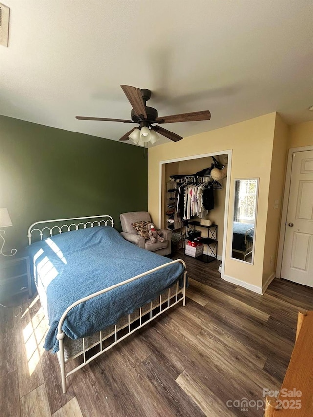 bedroom with ceiling fan, dark hardwood / wood-style flooring, and a closet