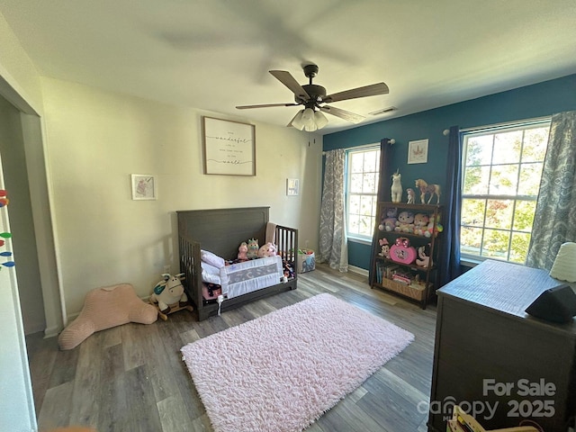 living area featuring ceiling fan, plenty of natural light, and dark wood-type flooring