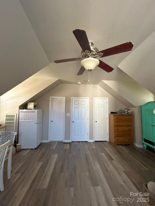 additional living space with ceiling fan, dark wood-type flooring, and vaulted ceiling