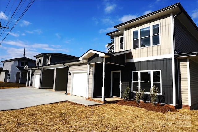 view of front facade featuring board and batten siding, an attached garage, and concrete driveway