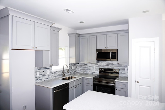 kitchen with a sink, appliances with stainless steel finishes, and gray cabinetry