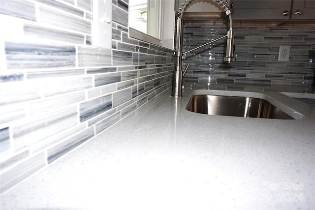 interior details featuring decorative backsplash and sink