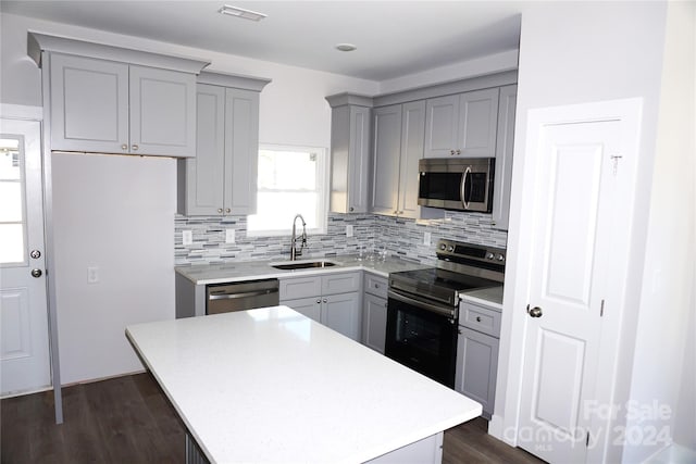 kitchen featuring visible vents, tasteful backsplash, a sink, appliances with stainless steel finishes, and gray cabinetry