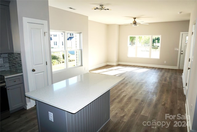 kitchen with a ceiling fan, visible vents, tasteful backsplash, dark wood finished floors, and light countertops
