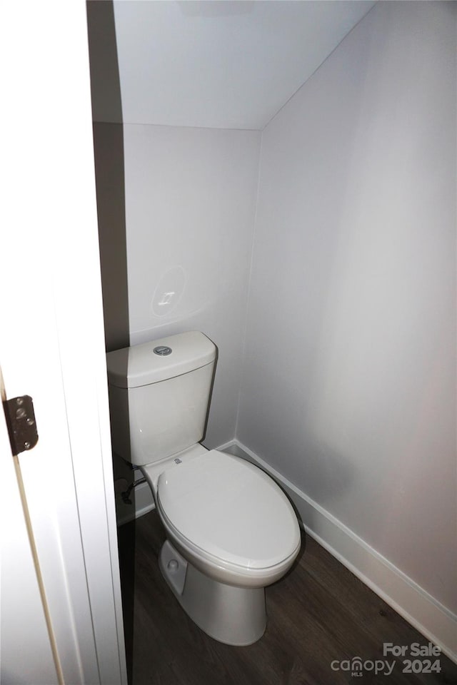 bathroom featuring baseboards, toilet, and wood finished floors