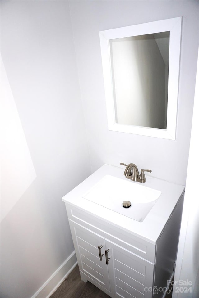 bathroom featuring vanity, baseboards, and wood finished floors