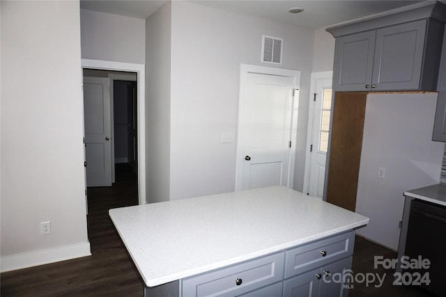 kitchen with gray cabinets, a center island, and dark hardwood / wood-style flooring