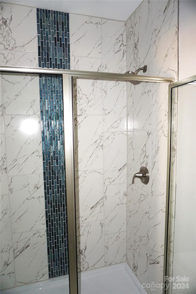 bathroom with a shower with door