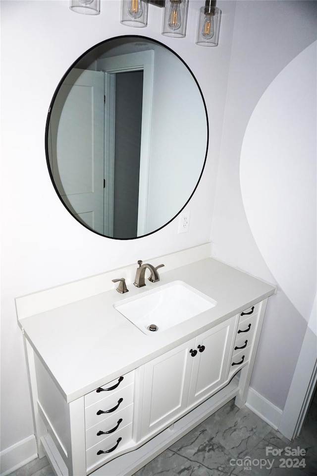 bathroom with baseboards, marble finish floor, and vanity