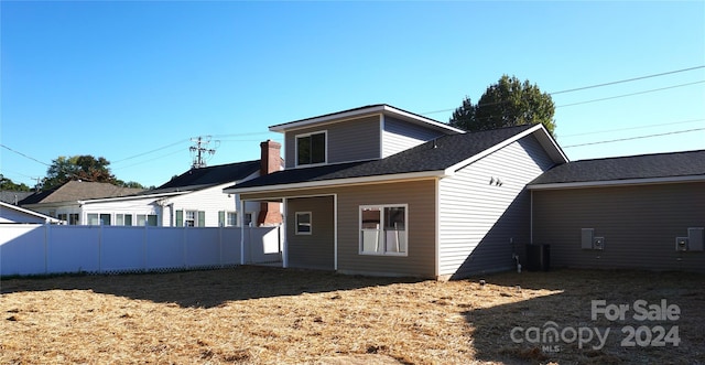 rear view of house featuring fence and central AC unit