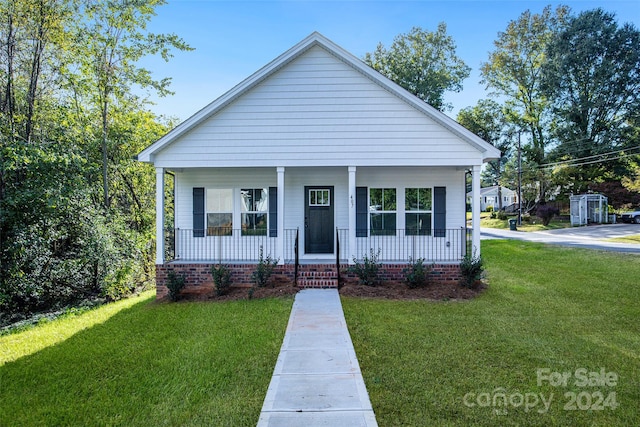 bungalow-style home with a front yard and covered porch