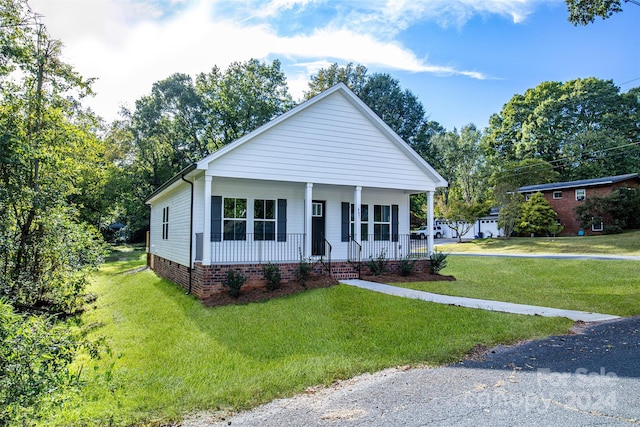 view of front of property with covered porch and a front yard