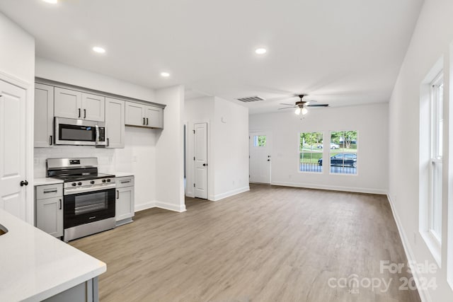 kitchen featuring appliances with stainless steel finishes, light hardwood / wood-style flooring, gray cabinetry, and ceiling fan