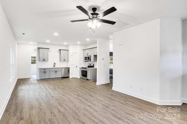 kitchen featuring gray cabinets, stainless steel appliances, and light hardwood / wood-style floors