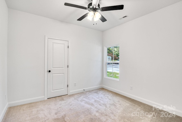 spare room featuring light carpet and ceiling fan