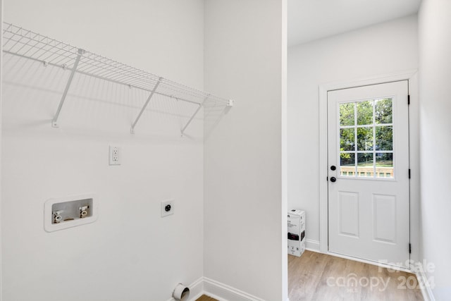 laundry room with hookup for an electric dryer, hookup for a washing machine, heating unit, and light hardwood / wood-style floors