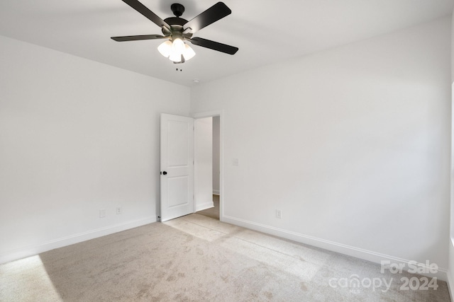 spare room with ceiling fan and light colored carpet