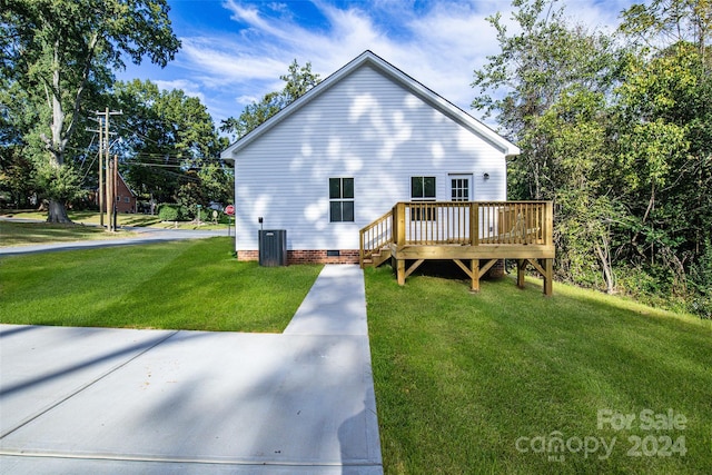 exterior space with a wooden deck, a yard, and central AC unit