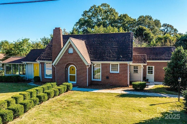 view of front of home featuring a front yard and a sunroom