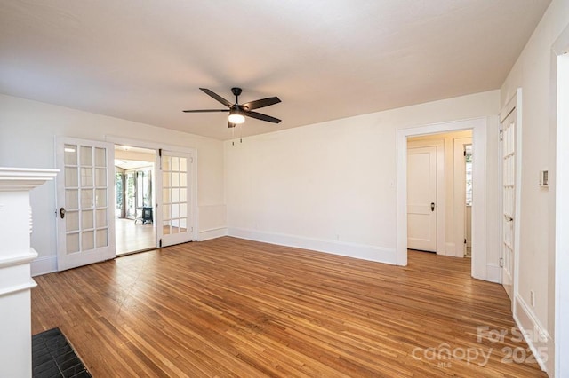 spare room with ceiling fan, hardwood / wood-style floors, and french doors