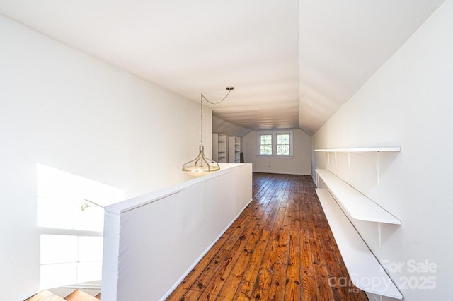 corridor with vaulted ceiling and dark hardwood / wood-style flooring