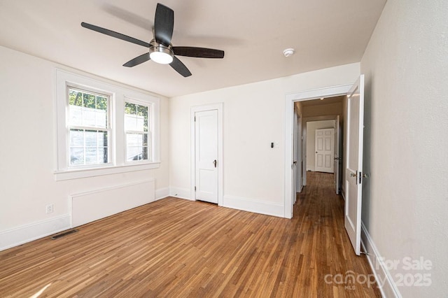 unfurnished bedroom with a closet, ceiling fan, and hardwood / wood-style flooring