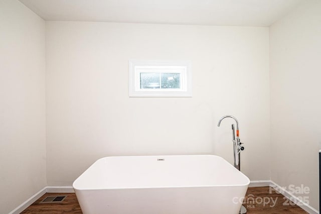 bathroom featuring a tub and hardwood / wood-style flooring