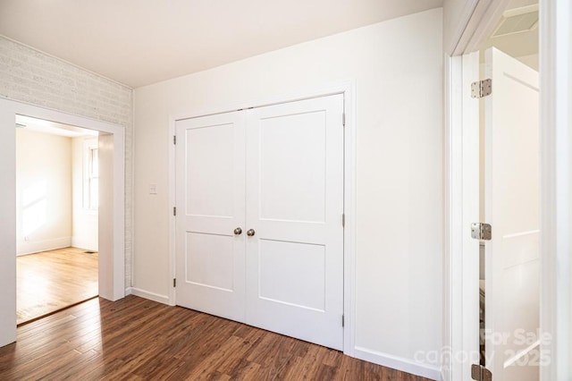 unfurnished bedroom featuring dark wood-type flooring and a closet