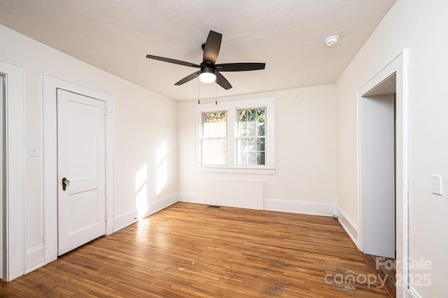 empty room featuring ceiling fan and hardwood / wood-style floors